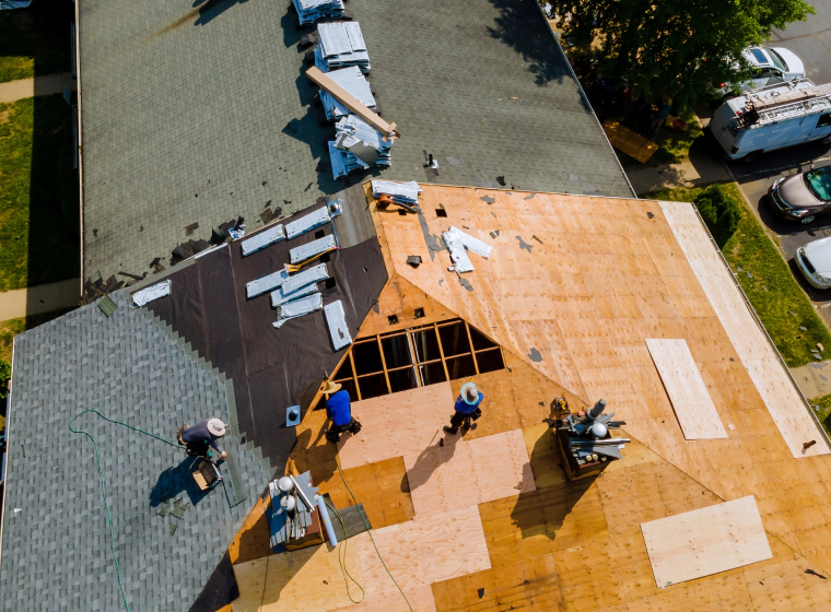 roofing installation with some contractors on top of a roofing